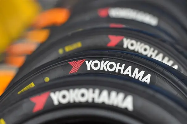 Fileira de pneus Yokohama com a logomarca vermelha e branca no flanco, ilustrando por que o pneu Yokohama é bom